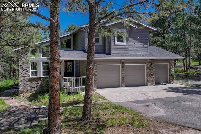 970 Bend In The Trail Rd, Monument, CO 80132 - view of front facade featuring stone siding, an attached garage, concrete driveway, covered porch, and a shingled roof