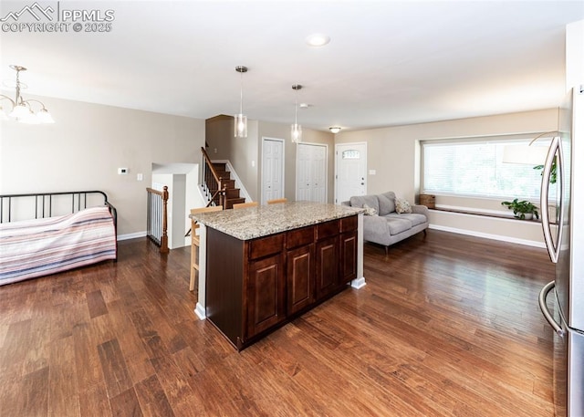3730 Deep Haven Dr, Colorado Springs, CO 80920 - kitchen featuring open floor plan, dark wood-type flooring, freestanding refrigerator, dark brown cabinetry, and hanging light fixtures