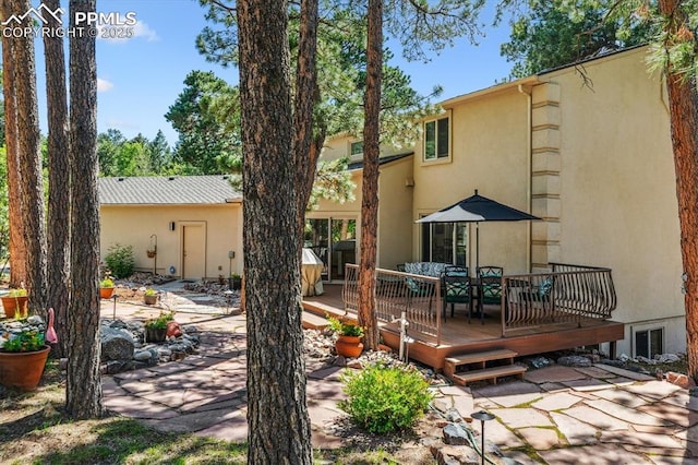 18971 Shadowood Dr, Monument, CO 80132 - back of house featuring a wooden deck, stucco siding, and a patio