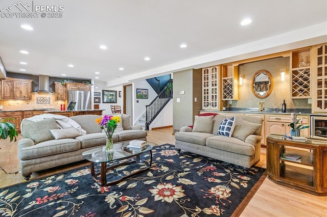 18971 Shadowood Dr, Monument, CO 80132 - living room with bar with sink, light wood-style floors, stairs, and recessed lighting