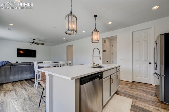 6237 Bodacious Cir, Colorado Springs, CO 80923 - kitchen featuring appliances with stainless steel finishes, a ceiling fan, light wood-style floors, open floor plan, and pendant lighting