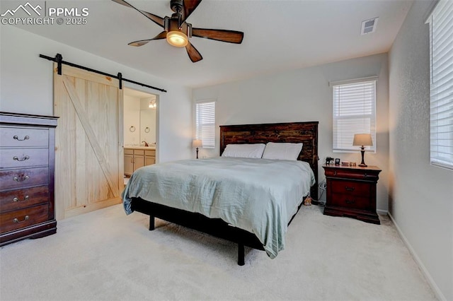 6237 Bodacious Cir, Colorado Springs, CO 80923 - carpeted bedroom with a barn door, multiple windows, ensuite bathroom, and a ceiling fan