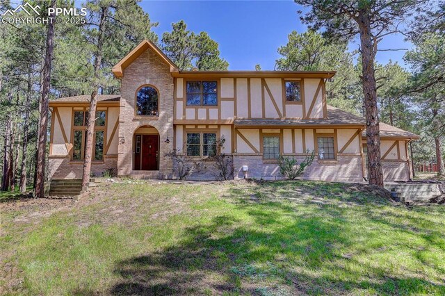 70 Long Bow Cir, Monument, CO 80132 - view of front facade featuring stucco siding, a front lawn, and brick siding