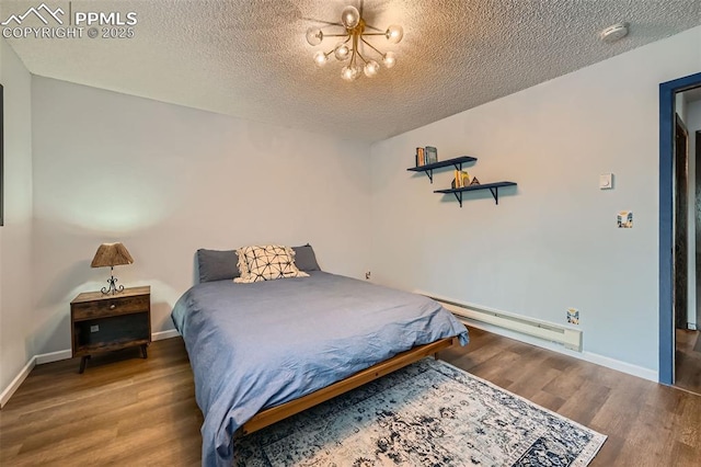 3324 W Kiowa St, Colorado Springs, CO 80904 - bedroom featuring a baseboard heating unit, a textured ceiling, wood finished floors, and a chandelier