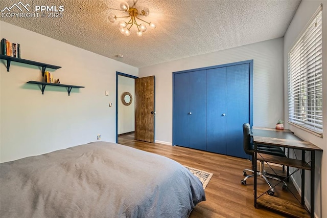 3324 W Kiowa St, Colorado Springs, CO 80904 - bedroom with a textured ceiling, wood finished floors, a closet, and a chandelier