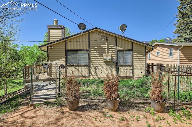 3324 W Kiowa St, Colorado Springs, CO 80904 - view of side of property with a chimney and a gate