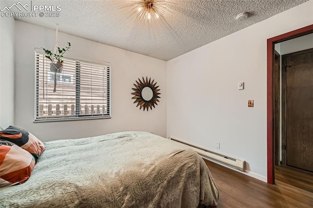 3324 W Kiowa St, Colorado Springs, CO 80904 - bedroom featuring a baseboard heating unit, wood finished floors, and a textured ceiling