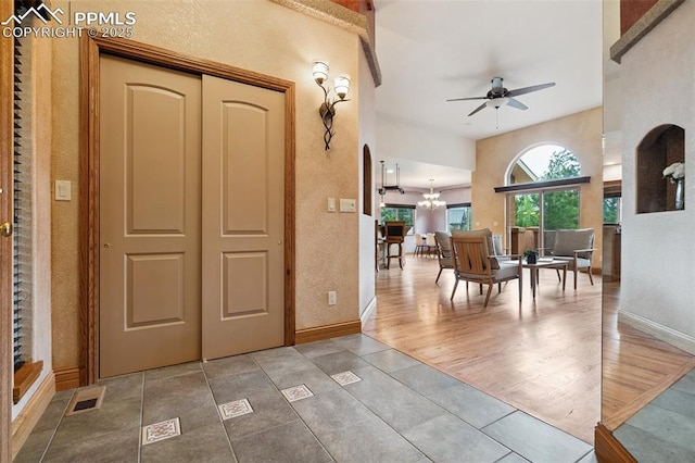 20401 High Pines Dr, Monument, CO 80132 - entrance foyer featuring ceiling fan, arched walkways, a chandelier, a textured wall, and tile patterned flooring