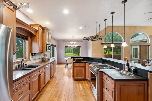 20401 High Pines Dr, Monument, CO 80132 - kitchen featuring stainless steel appliances, light wood-style floors, brown cabinetry, a chandelier, and recessed lighting