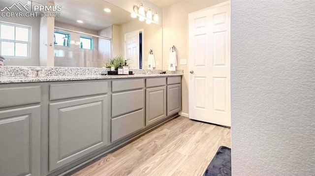 6640 Backcountry Loop, Colorado Springs, CO 80927 - full bath with wood finished floors, double vanity, a shower stall, and recessed lighting