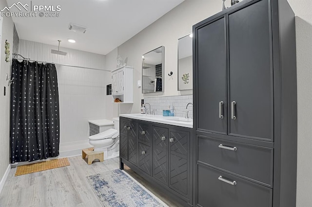 4540 Fountain Ave, Cascade, CO 80809 - bathroom featuring wood finished floors, double vanity, a shower, and decorative backsplash
