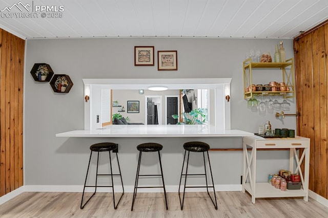4540 Fountain Ave, Cascade, CO 80809 - kitchen featuring wood finished floors, a breakfast bar area, a peninsula, wood walls, and wood ceiling