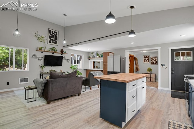 4540 Fountain Ave, Cascade, CO 80809 - kitchen with wood counters, light wood-style flooring, pendant lighting, white cabinetry, and open floor plan