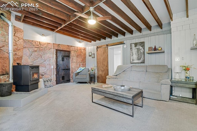 4540 Fountain Ave, Cascade, CO 80809 - carpeted living area with a wood stove, beam ceiling, and ceiling fan