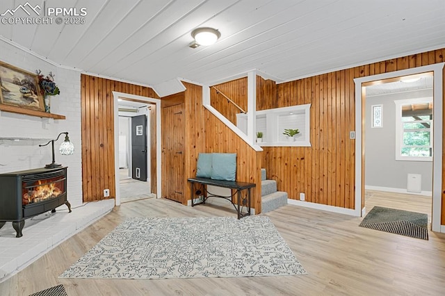 4540 Fountain Ave, Cascade, CO 80809 - foyer entrance with a wood stove, stairway, wooden walls, wood finished floors, and crown molding