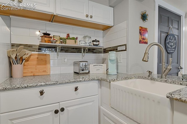 4540 Fountain Ave, Cascade, CO 80809 - kitchen with backsplash, white cabinetry, open shelves, and light stone countertops