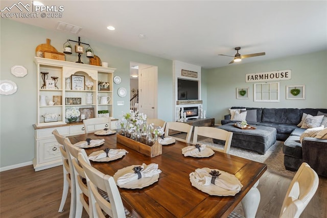 6469 Bodacious Cir, Colorado Springs, CO 80923 - dining space featuring a ceiling fan, dark wood-type flooring, and a glass covered fireplace