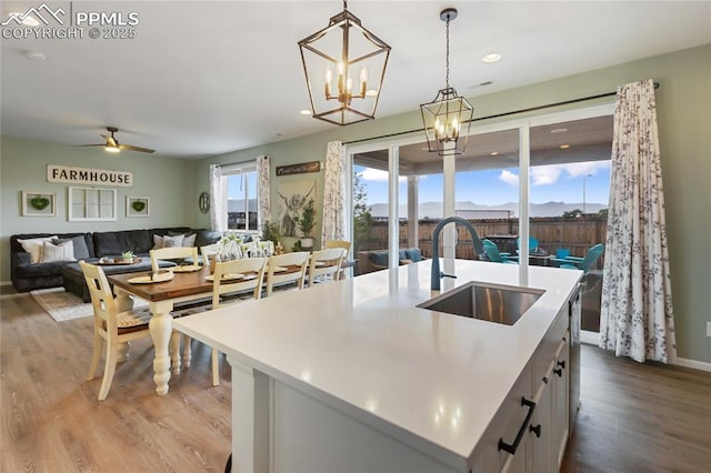 6469 Bodacious Cir, Colorado Springs, CO 80923 - kitchen with wood finished floors, decorative light fixtures, light countertops, ceiling fan, and a chandelier