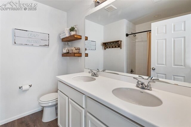 6469 Bodacious Cir, Colorado Springs, CO 80923 - full bath featuring double vanity, a shower with curtain, and wood finished floors