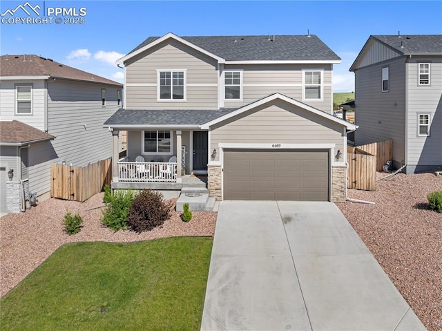 6469 Bodacious Cir, Colorado Springs, CO 80923 - view of front of house with a porch, driveway, roof with shingles, and stone siding