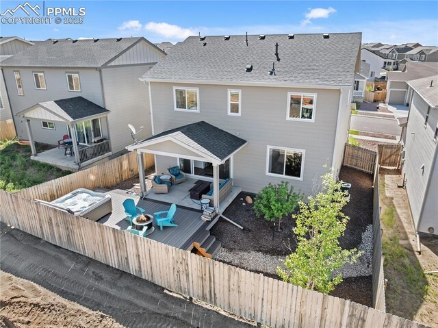 6469 Bodacious Cir, Colorado Springs, CO 80923 - back of house featuring a deck, a residential view, a shingled roof, a fenced backyard, and an outdoor living space with a fire pit