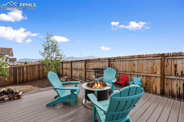 6469 Bodacious Cir, Colorado Springs, CO 80923 - deck with a fire pit, a mountain view, and a fenced backyard