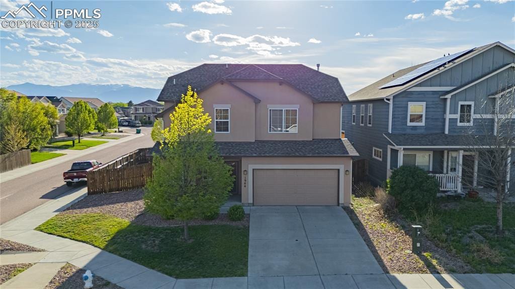 1944 Reed Grass Way, Colorado Springs, CO 80915 - view of front of house with an attached garage, driveway, stucco siding, and a residential view