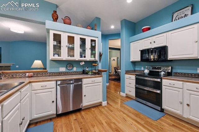 5584 Calamity Jane Ln, Colorado Springs, CO 80923 - kitchen featuring stainless steel appliances, light wood finished floors, white cabinetry, and recessed lighting