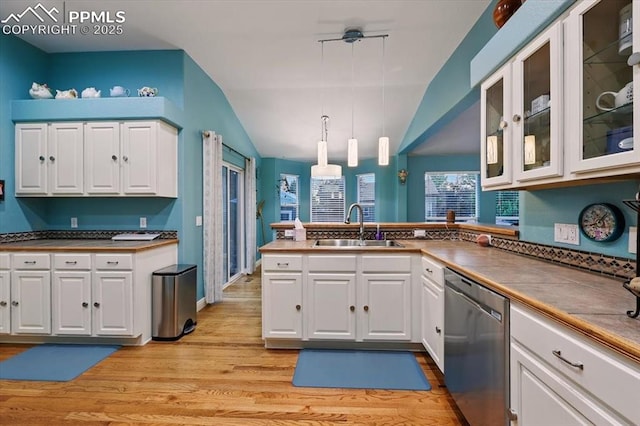 5584 Calamity Jane Ln, Colorado Springs, CO 80923 - kitchen featuring stainless steel dishwasher, vaulted ceiling, white cabinets, light wood-style flooring, and a peninsula