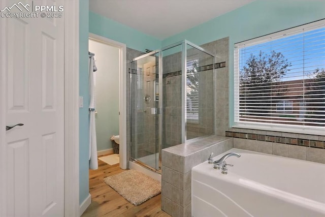 5584 Calamity Jane Ln, Colorado Springs, CO 80923 - full bathroom with a stall shower, a garden tub, and wood finished floors