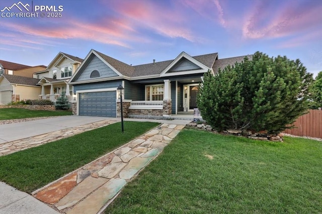 5584 Calamity Jane Ln, Colorado Springs, CO 80923 - craftsman-style house with covered porch, a garage, driveway, stone siding, and a shingled roof
