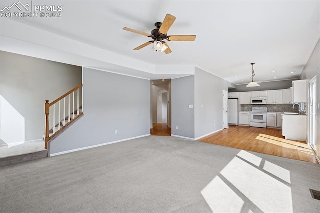 1562 Lookout Springs Dr, Colorado Springs, CO 80921 - unfurnished living room with stairs, light carpet, a ceiling fan, arched walkways, and recessed lighting