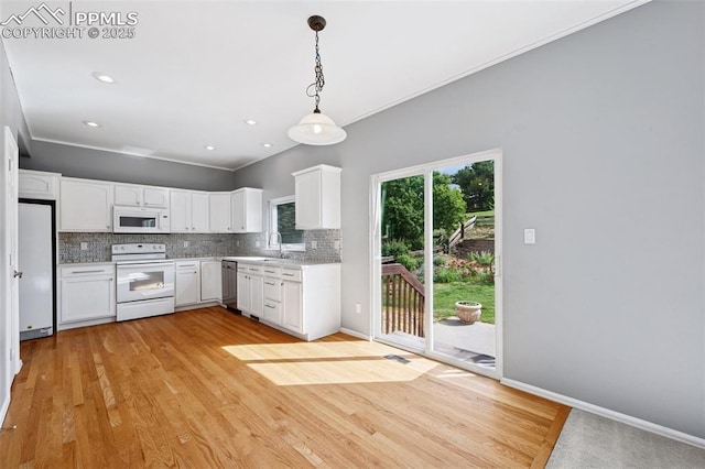 1562 Lookout Springs Dr, Colorado Springs, CO 80921 - kitchen with white appliances, decorative backsplash, pendant lighting, white cabinetry, and light wood-type flooring