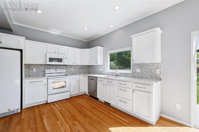 1562 Lookout Springs Dr, Colorado Springs, CO 80921 - kitchen with white appliances, decorative backsplash, white cabinets, light wood finished floors, and light countertops
