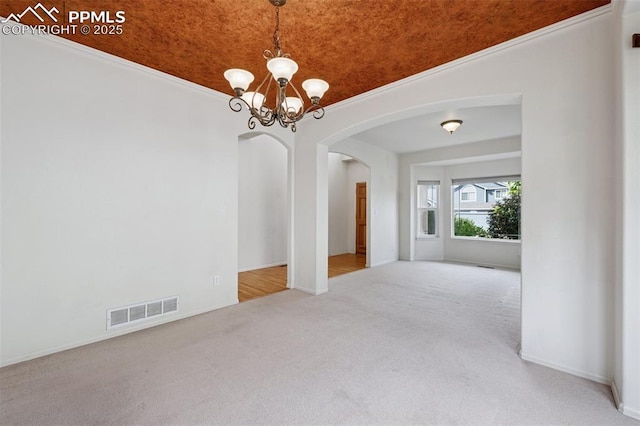 1562 Lookout Springs Dr, Colorado Springs, CO 80921 - carpeted empty room featuring arched walkways, a chandelier, and ornamental molding