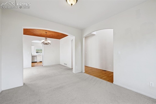 1562 Lookout Springs Dr, Colorado Springs, CO 80921 - empty room featuring arched walkways, carpet flooring, and a chandelier