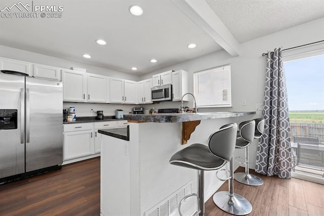 245 Turf Trail Pl, Fountain, CO 80817 - kitchen featuring appliances with stainless steel finishes, dark wood-type flooring, white cabinetry, dark countertops, and recessed lighting