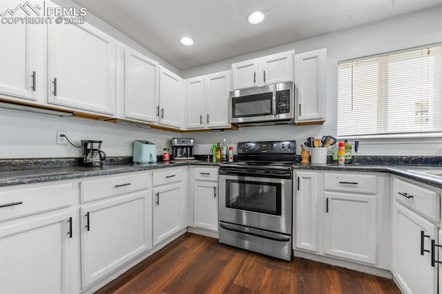 245 Turf Trail Pl, Fountain, CO 80817 - kitchen featuring appliances with stainless steel finishes, white cabinetry, dark countertops, dark wood finished floors, and recessed lighting