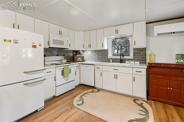 53 Iris Rd, Woodland Park, CO 80863 - kitchen featuring white appliances, a wall mounted air conditioner, light wood-style floors, and white cabinets