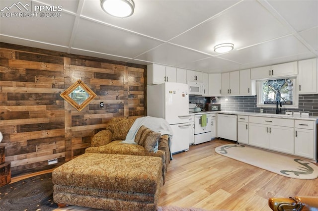 53 Iris Rd, Woodland Park, CO 80863 - kitchen featuring white appliances, light countertops, decorative backsplash, light wood-style flooring, and white cabinets