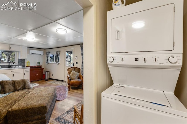 53 Iris Rd, Woodland Park, CO 80863 - laundry room with stacked washing machine and dryer, light wood-style floors, and an AC wall unit