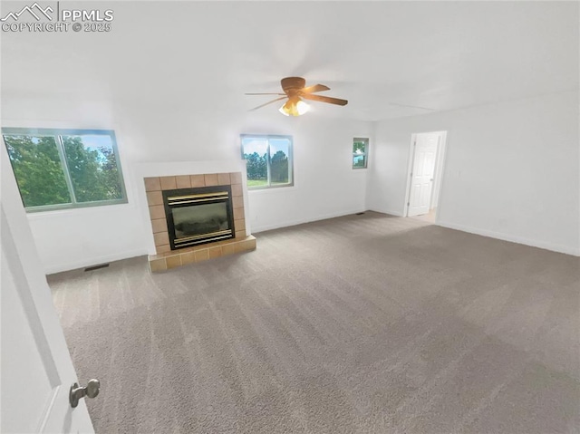 570 Ore Cart Way, Monument, CO 80132 - unfurnished living room with a ceiling fan, plenty of natural light, a tile fireplace, and carpet