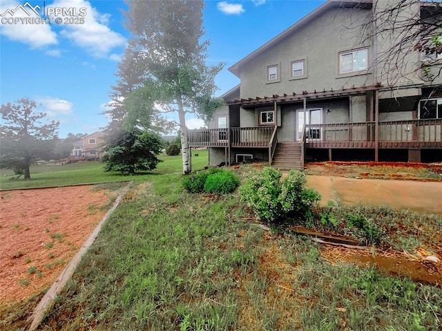 570 Ore Cart Way, Monument, CO 80132 - rear view of property with stucco siding, a wooden deck, and a yard