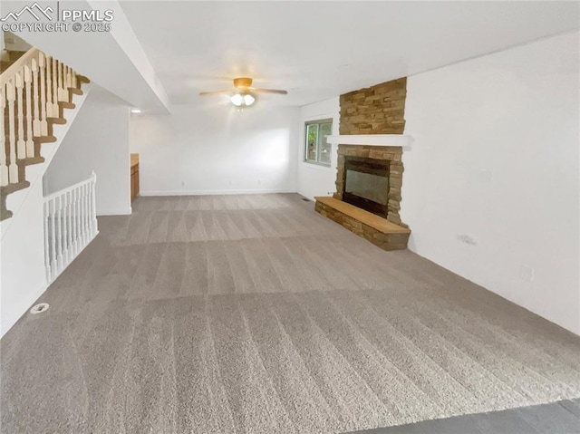 570 Ore Cart Way, Monument, CO 80132 - unfurnished living room with carpet, a ceiling fan, a fireplace, and stairs