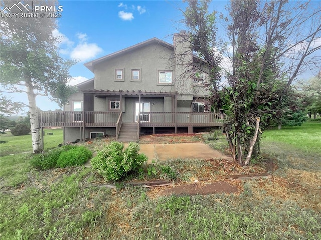 570 Ore Cart Way, Monument, CO 80132 - rear view of property featuring a wooden deck, stucco siding, and a chimney