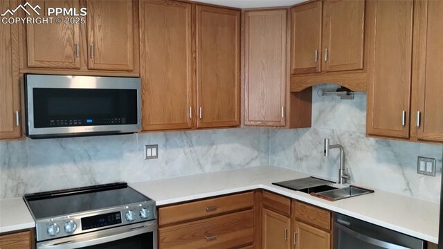2118 N Chestnut St, Colorado Springs, CO 80907 - kitchen with appliances with stainless steel finishes, decorative backsplash, light countertops, and brown cabinetry