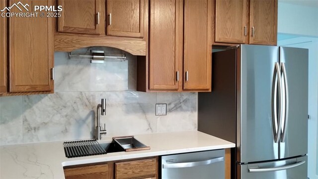 2118 N Chestnut St, Colorado Springs, CO 80907 - kitchen with stainless steel appliances, decorative backsplash, light countertops, and brown cabinetry