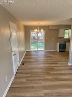5135 Webbed Foot Way, Colorado Springs, CO 80911 - unfurnished dining area featuring a textured ceiling, a chandelier, and wood finished floors