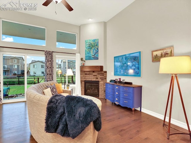 12646 Windingwalk Dr, Peyton, CO 80831 - living room with hardwood / wood-style floors, ceiling fan, a stone fireplace, and a towering ceiling