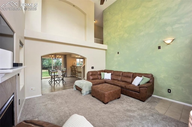 1880 Windover Ct, Fountain, CO 80817 - living room with arched walkways, a tile fireplace, carpet flooring, and a towering ceiling